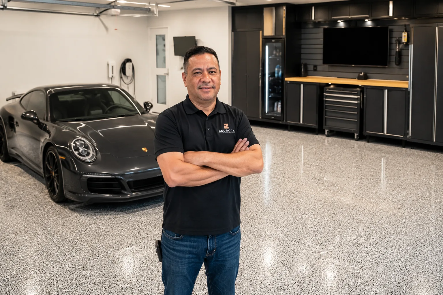 Victor standing on a finished flake garage floor with a Porsche in the background